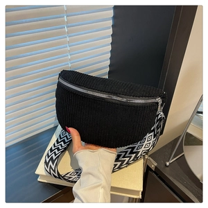 Detail of black corduroy saddle bag with adjustable wide geometric patterned strap