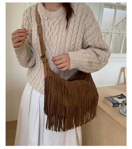 Dettaglio della borsa a tracolla bohemian marrone con trama scamosciata e frange