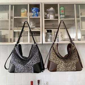 Detail view of large leopard print tote bags in grey and brown canvas and leather
