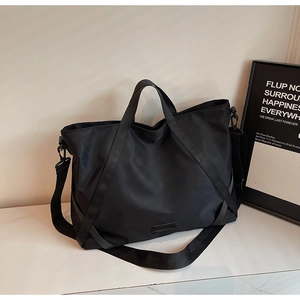 Nahaufnahme der schwarzen Nylon-Reisetasche mit Doppelgriffen und breitem Tragegurt