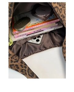 Top-down view of spacious leopard print tote interior with books and side pocket