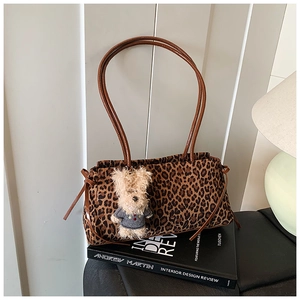 Detalle de bolso de lona con estampado de leopardo y colgante de cachorro de felpa