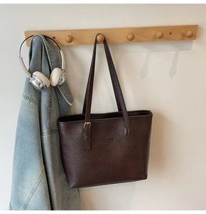 Close-up of vintage brown leather tote bag with embossed fashion bag New York logo text