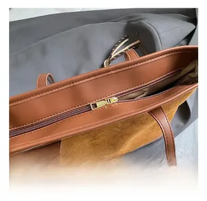 Dettaglio della cerniera dorata sulla borsa tote in pelle marrone testurizzata