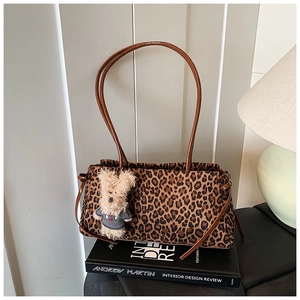 Detalle del bolso shopper de leopardo con asas de cuero y un colgante de cordero suave