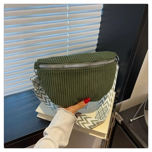 Detail of green corduroy saddle bag featuring silver zipper and checkered wide strap