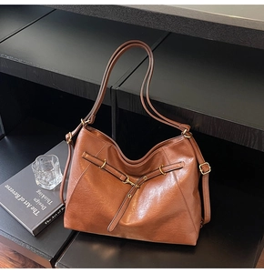 Detail view of the fine-textured caramel PU leather and vintage buckle on large tote bag