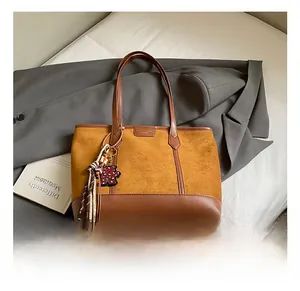 Dettaglio della texture della borsa tote marrone caramello con finiture in pelle