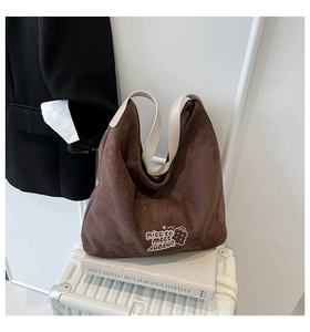 Close-up of leopard print tote bag with brown suede texture on a white suitcase
