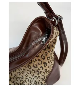 Close-up of the smooth silver zipper and leopard print fabric on a stylish tote bag