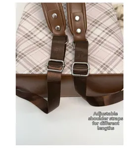 Detail view of pink plaid backpack featuring adjustable metal buckles and durable straps
