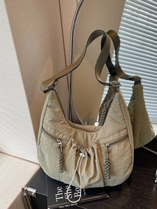 Olive green pleated nylon hobo bag with drawstring detail and multiple zipper pockets