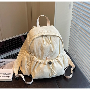 Close-up of cream canvas backpack featuring functional drawstring pocket and metal zippers