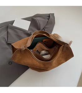 Detail of suede tote bag with inner pouch showing large capacity storage on grey blazer