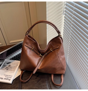Detail of brown leather tote bag with lychee texture and versatile shoulder straps