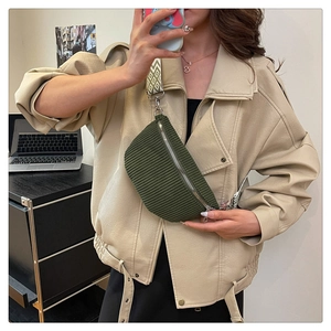 Olive green corduroy crossbody bag with geometric pattern strap shown on a model