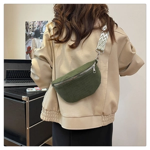 Detail of dark green corduroy saddle bag with wide geometric patterned shoulder strap
