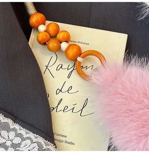 Détail des perles en bois orange et de la peluche rose pour accessoire de sac à main