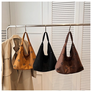 Detailed laser-cut flower patterns on suede shoulder bags in yellow, black and brown