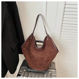 Close-up of vintage dark brown suede tote bag with geometric wing design and fine stitching
