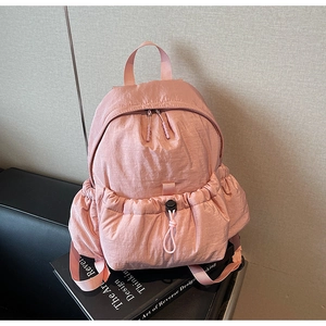 Detailed shot of pink canvas backpack featuring adjustable drawstrings and dual zippers