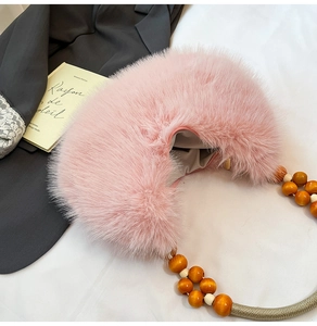 Détail du sac croissant en fausse fourrure rose avec poignée élégante en perles de bois
