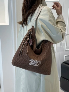 Large leopard print bucket tote bag with embroidery and charms on a female model