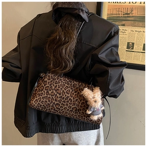 Detalle del bolso de hombro con estampado de leopardo y colgante de osito de peluche