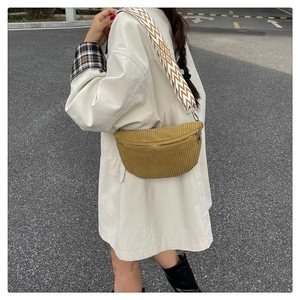 Detailed view of ginger yellow corduroy saddle bag with a geometric jacquard strap