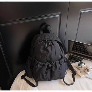 Detail of black nylon backpack with drawstring pocket and side mesh compartments