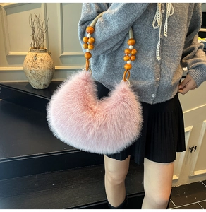 Gros plan du sac en fausse fourrure rose avec perles en bois sur la bandoulière