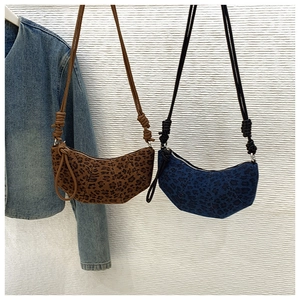 Detailed view of leopard print crescent bags with unique knotted shoulder strap design