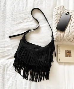 Detailopname van zwarte suède bohemien crossbodytas met lange franjes en riem