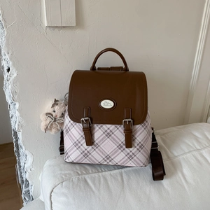 Detail of pink plaid backpack with brown leather flap and cute rabbit charm