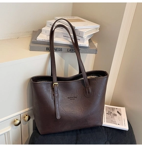 Detail of dark coffee tote bag featuring leather texture and New York fashion text