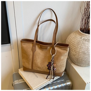 Dettaglio della borsa tote in pelle scamosciata marrone con finiture in pelle su libri