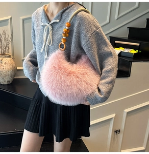 Détail du sac croissant en fausse fourrure rose avec poignée en perles de bois et corde