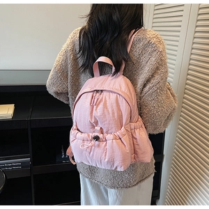 Pink canvas backpack with wrinkled texture fabric shown on model in home setting