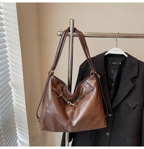 Detailed view of dark brown vintage leather tote with metal ring and side drawstrings