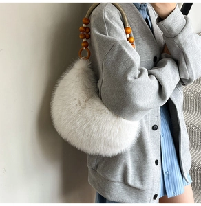 Détail du sac hobo en peluche blanche avec poignée unique en perles de bois brun