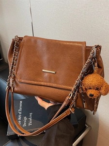 Retro brown leather underarm bag with gold chain strap and plush puppy charm