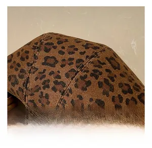 Close-up of leopard print textured fabric with twill weave and brown leather handle