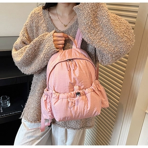 Pink lightweight nylon backpack featuring a drawstring front pocket and adjustable buckle