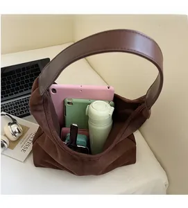 Detail showing the spacious interior of the brown suede hobo bag with daily essentials