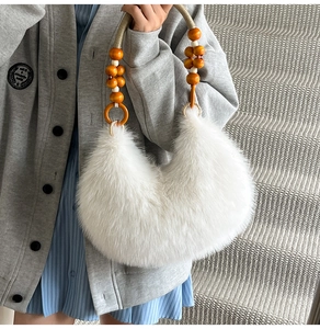 Détail du sac hobo en fausse fourrure blanche avec poignée tressée à perles colorées
