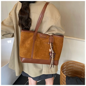 Borsa tote in camoscio marrone con manici in pelle indossata da una modella vista da dietro