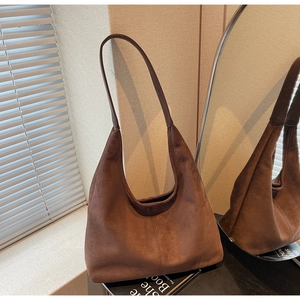 Close-up of vintage dark brown suede hobo bag showing fine vertical stitching and texture