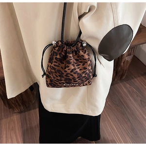Détail du sac seau à imprimé léopard avec cordon de serrage et texture en velours doux