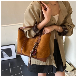 Detail of caramel suede leather tote bag with braided lanyard and side strap texture
