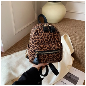 Detailed view of mini leopard print backpack with gold zippers and black leather top handle